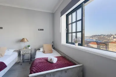 a bedroom with a bed and a window with a view at MyRiverPlace N 5 River View Porto apartments in Vila Nova de Gaia