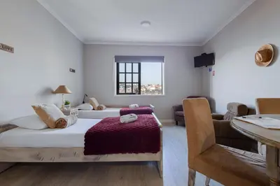 a bedroom with two beds and a couch and a window at MyRiverPlace N 5 River View Porto apartments in Vila Nova de Gaia