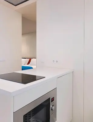 a white kitchen with a stove top oven at Ribeira Trendy Flat in Medieval Mercadores Street in Porto