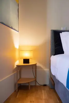 a bedroom with a bed and a table with a lamp at Ribeira Trendy Flat in Medieval Mercadores Street in Porto