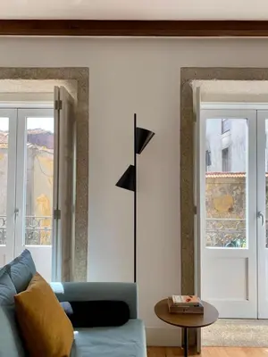 a living room with a blue couch and two windows at Oporto Chic&Cozy - São Bento da Vitória in Porto
