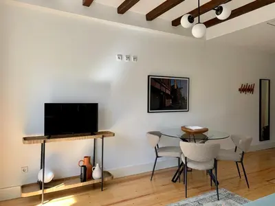 a living room with a table and chairs and a tv at Oporto Chic&Cozy - São Bento da Vitória in Porto