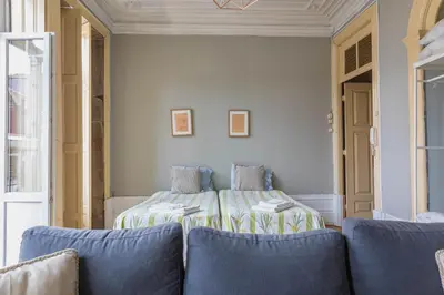 a bedroom with a bed and two blue chairs at Rustic Apartment in Poveiros in Porto
