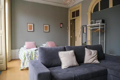 a living room with a blue couch with pillows at Rustic Apartment in Poveiros in Porto
