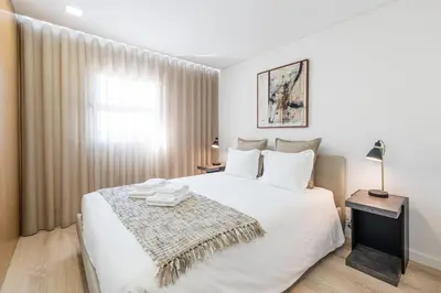 a bedroom with a large white bed and a window at GuestReady - Tigerlily in Porto