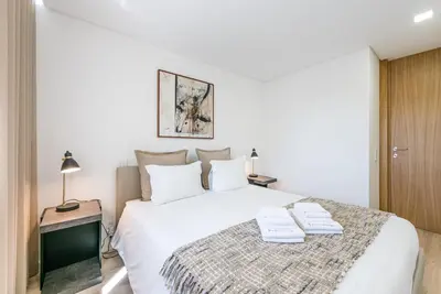 a bedroom with a white bed with two towels on it at GuestReady - Tigerlily in Porto