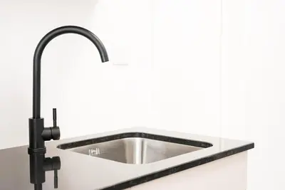 a stainless steel sink in a white kitchen at GuestReady - Subzero Design in Porto