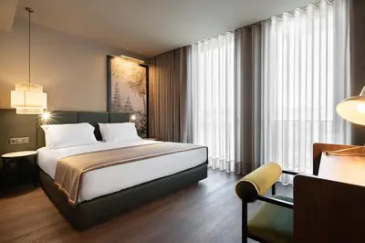 a hotel room with a bed and a chair at Exe Essenzia Porto in Porto