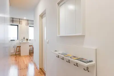 a white kitchen with a shelf on the wall at GuestReady - Lazaro Studio in Porto