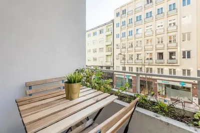 a wooden bench on a balcony with a building at GuestReady - Square Painted Ceuta in Porto