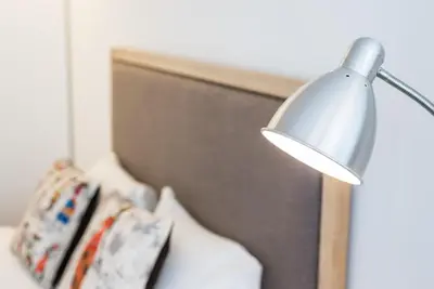a silver lamp sitting next to a bed at GuestReady - Square Painted Ceuta in Porto