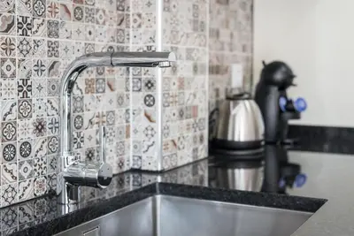 a kitchen sink with a faucet on a counter at GuestReady - Redamancy Flat in Porto