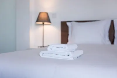 a pile of towels on a bed with a lamp at GuestReady - Redamancy Flat in Porto