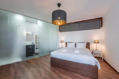 a bedroom with a large white bed and wooden floors at GuestReady - Redamancy Flat in Porto