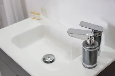 a sink with a faucet on a white counter at GuestReady - Redamancy Flat in Porto