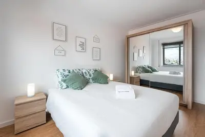 a bedroom with a large white bed and a mirror at GuestReady - Porto Fantastic View in Vila Nova de Gaia