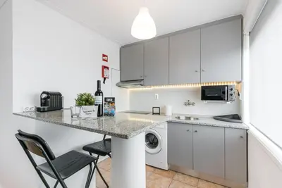 a kitchen with a counter and a washer and dryer at GuestReady - Porto Fantastic View in Vila Nova de Gaia