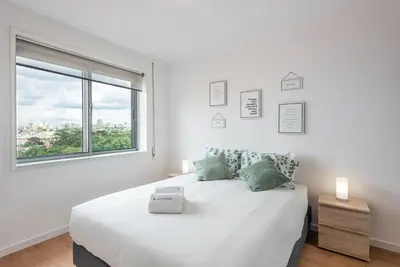a white bedroom with a large bed and a window at GuestReady - Porto Fantastic View in Vila Nova de Gaia