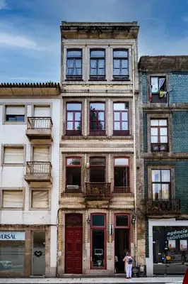 a tall building with many windows on a street at Nomad's Easy Stay - 1BED Sunrise Cedofeita in Porto