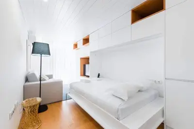 a white bedroom with a large bed and a lamp at Bright Studio in the Heart of Porto by Great&Cosy in Porto