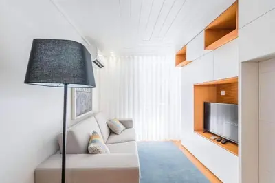 a living room with a couch and a flat screen tv at Bright Studio in the Heart of Porto by Great&Cosy in Porto