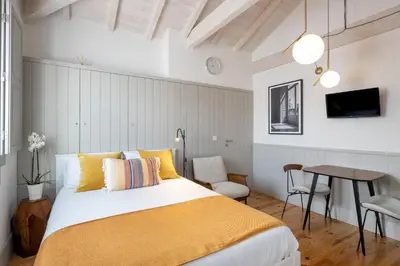 a bedroom with a bed and a table with chairs at CASA JOY Cathedral apartment in Porto