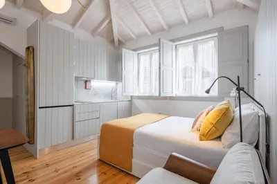 a white bedroom with a bed and a couch at CASA JOY Cathedral apartment in Porto