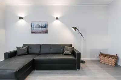 a living room with a black couch and a lamp at GuestReady - Music Area in Porto