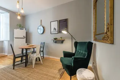 a living room with a table and a chair at GuestReady - Miragaia Green in Porto