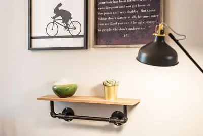 a lamp and a shelf with a vase on it at GuestReady - Miragaia Green in Porto