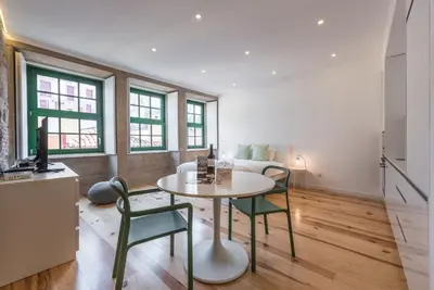 a living room with a table and two chairs at GuestReady - Mezuzah Yellow in Porto