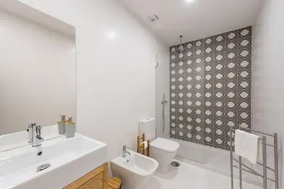 a bathroom with a white sink and a toilet at GuestReady - Mezuzah Green in Porto