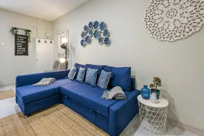 a blue couch in a living room with plates on the wall at GuestReady - Miragaia Historical Sight in Porto