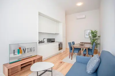 a living room with a blue couch and a tv at Liiiving in Porto - City View Apartments in Porto