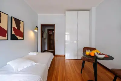 a bedroom with a bed and a table with fruit on it at Impar Studios Deluxe in Porto