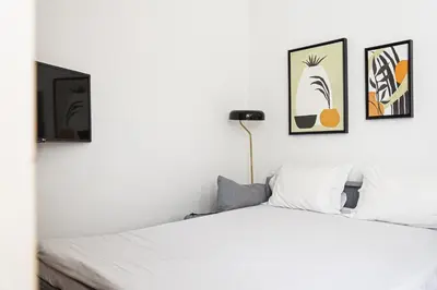 a bedroom with a white bed with three pictures on the wall at Impar luxury residence in Porto
