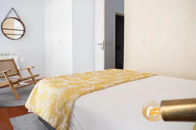 a bedroom with a bed with a yellow blanket on it at Impar luxury residence in Porto