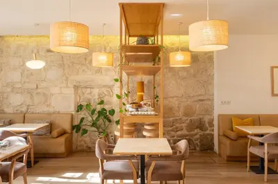 a restaurant with tables and chairs and chandeliers at Memoria Porto FLH Hotels in Porto