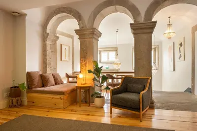 a living room with a couch and a chair at Memoria Porto FLH Hotels in Porto