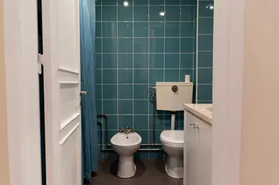 a green tiled bathroom with a toilet and a sink at Ninho @ Francos in Porto
