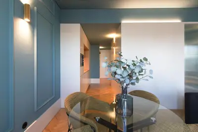 a dining room with a glass table with chairs and a vase with flowers at HM - Infante Riverside Apartment N in Porto