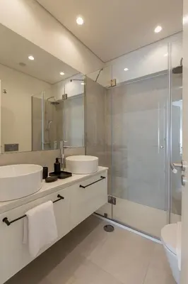a bathroom with two sinks and a glass shower at ORM Antero Apartment in Porto