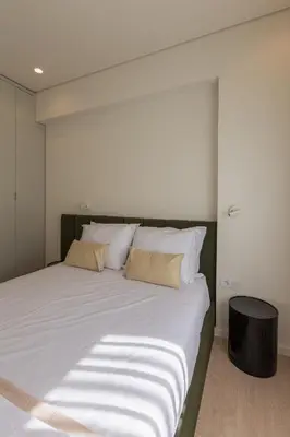a bed with white sheets and pillows in a room at ORM Antero Apartment in Porto