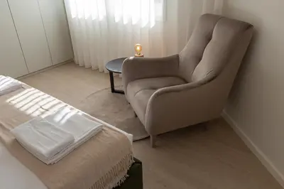 a bedroom with a chair next to a bed at ORM Antero Apartment in Porto