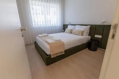 a bedroom with a large bed with white sheets and pillows at ORM Antero Apartment in Porto