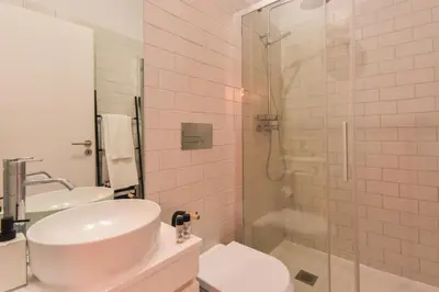 a white bathroom with a sink and a shower at Sweet Home Firmeza in Porto