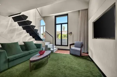 a living room with a green couch and a tv at Hilton Porto Gaia in Vila Nova de Gaia