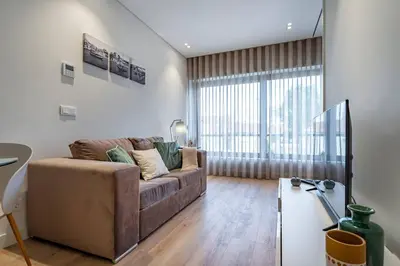 a dining room with a table and chairs and a window at Antas Park Flat With Pool in Porto