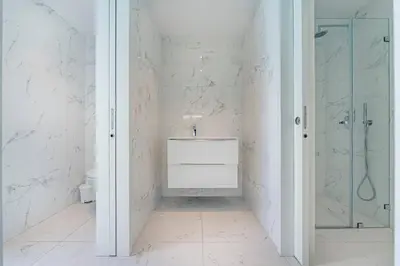 a white sink in a bathroom with two toilets at Antas Park Flat With Pool in Porto