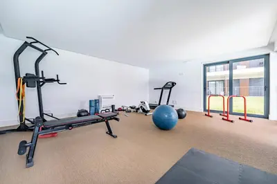 a gym with several treadmills and a gym ball at Antas Park Flat With Pool in Porto